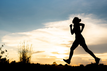 silhouette woman running alone at beautiful sunset in the park.