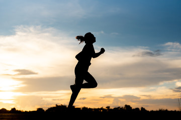 silhouette woman running alone at beautiful sunset in the park.