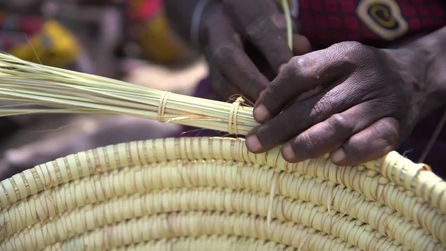 African woman basket weaving.