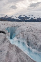 Blue meltwater carves through a glacier in Alaska