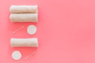 Products made of cotton. Bath accessories. Towels, cotton pads and swabs near dry cotton flowers on pink background top view pattern copy space