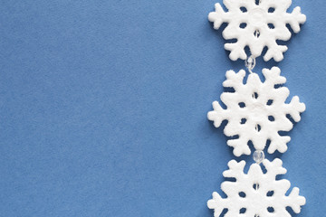 Christmas frame of white snowflake. Minimal New Year concept on blue background. Flat lay.