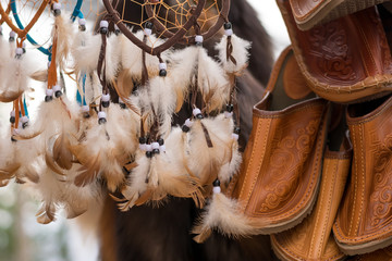 white feather amulets and national Slippers hanging on the market for sale