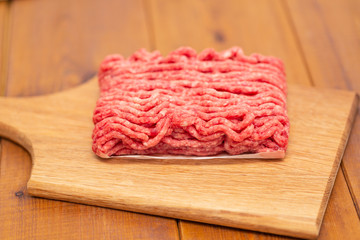 Portion of Minced Meat on an wooden table 