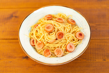 Pasta spaghetti with fried sausage in plate on table