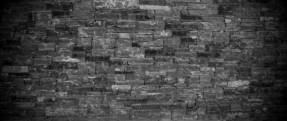 Panoramic view of the black stone wall. Dark background of slate bricks