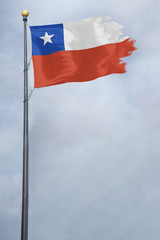 Worn and tattered Chile flag blowing in the wind on a cloudy day
