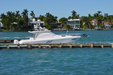 Fototapeta na wymiar High -end sport fishing boat cruising past luxury island homes on Rivo Alto in Miami Beach,Florida