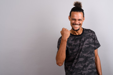 Young bearded handsome African man against gray background