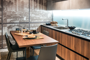 Modern fitted kitchen with table and glass wall