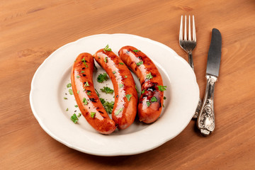 A photo of a plate of fried sausages on a dark rustic wooden background with copy space