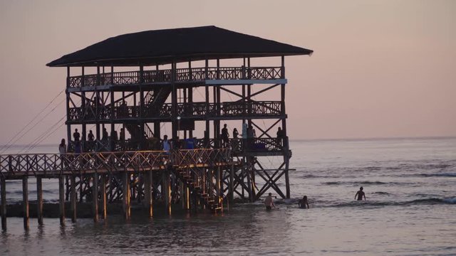 Panning right across the Cloud9 boardwalk with the sun low and out of frame, silhouetted against a cloudy sky, filmed in UHD 4K