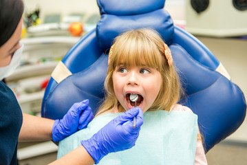 Little girl sitts in the dentist's office