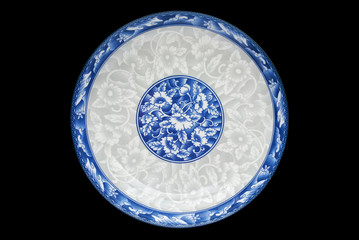 Blue and white porcelain of the flower pattern on dish isolated on black background. Above view.