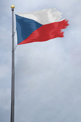 Fototapeta na wymiar Worn and tattered Czech Republic flag blowing in the wind on a cloudy day
