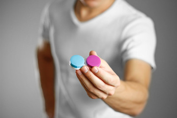 A man holds an eye lens. Close up. Isolated background