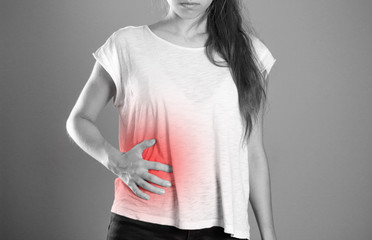 Girl holding her side. Pain in the liver. Syros liver. Close up. Isolated background