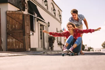 Poster Woman enjoying a skateboard ride on the street © Jacob Lund