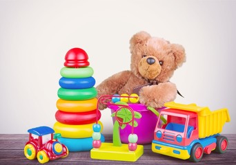 Toys collection and teddy bear on wooden