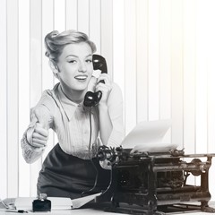 Attractive young woman working on vintage typewriter on