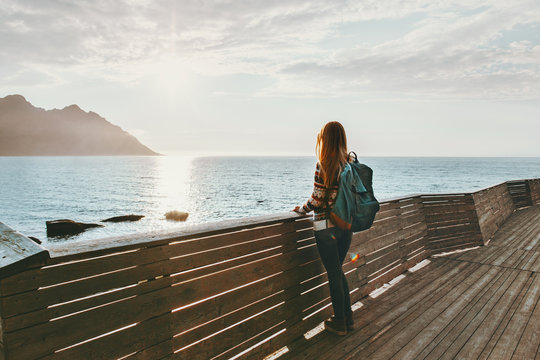 Traveler woman contemplating standing alone on bridge travel lifestyle vacations outdoor solitude emotions sunset sea view