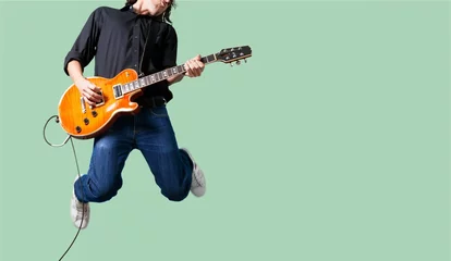 Foto op Plexiglas Male Guitarist playing music on grey wall © BillionPhotos.com