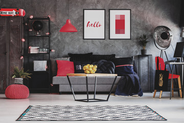 Raspberry red accents in stylish living room interior with grey industrial furniture, modern coffee...