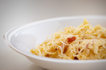 Macaroni carbonara presented on a white dish