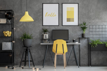Grey home office with yellow accents and urban jungle in modern apartment, real photo with mockup
