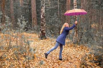 girl with umbrella in the autumn forest