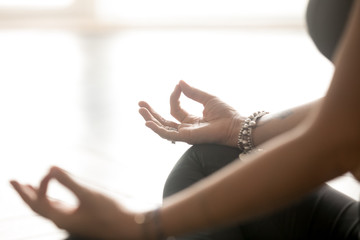 Young sporty yogi yoga woman, meditating doing Easy Seat exercise, Sukhasana pose with mudra...