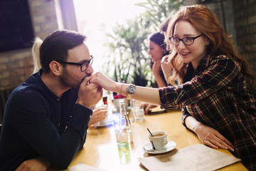 Handsome man flirting with cute woman in restaurant
