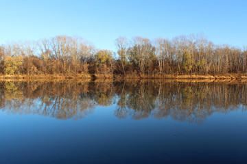 Obraz premium Autumn landscape with reflection of trees in the river