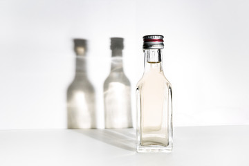 One bottle of alcohol and two shadows on the wall.