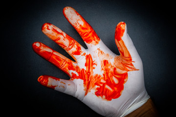 Bloody surgical glove on black background