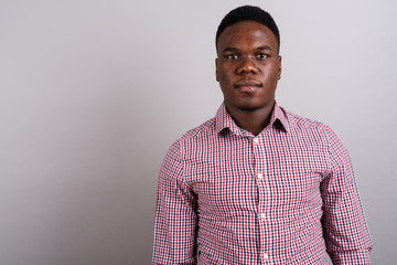 Obraz premium Young African businessman standing against white background