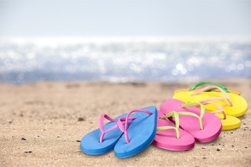 Fototapeta premium Pairs Of Flip-flops On Beach, vacation concept