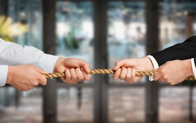 Business people pulling rope in opposite directions