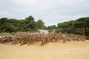 Stored old rusty ship anchors in rows in front of a Mediterranean landscape in Spain