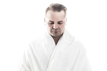 Calm man with white cowl on white background