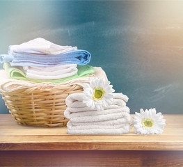 Laundry Basket with colorful towels on background