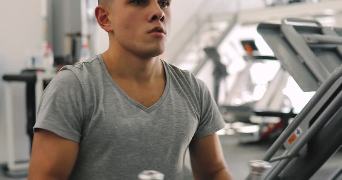 Young beginner man exercising in gym training with weight