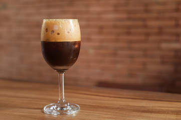 Iced coffee in glass on wooden table