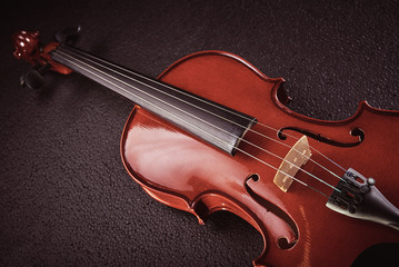 part of a violin on a black background with hard light