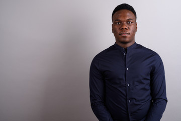 Portrait of young African businessman against white background
