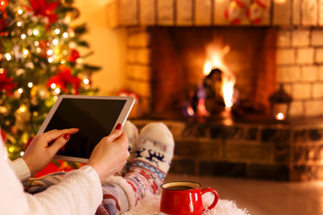 Woman sitting by fireplace - Powered by Adobe