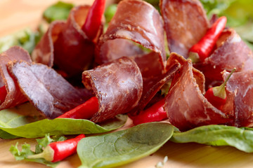 Dry beef jerky with herbs and red peppers.