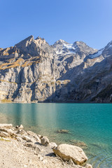 Naklejka na ściany i meble Wandern im Berner Oberland mit Blick auf die Schweizer Alpen und einen Bergsee – Oeschinensee, Kanton Bern, Schweiz