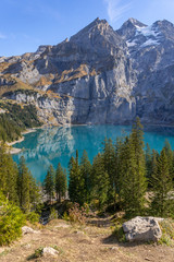 Fototapeta na wymiar Wandern im Berner Oberland mit Blick auf die Schweizer Alpen und einen Bergsee – Oeschinensee, Kanton Bern, Schweiz
