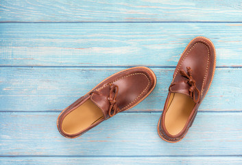 Brown oil pull up leather men’s loafer shoes isolated on wooden background. Fashion advertising shoes photos.